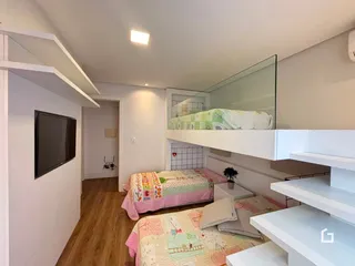 Quarto com duas camas e mezanino em um apartamento.