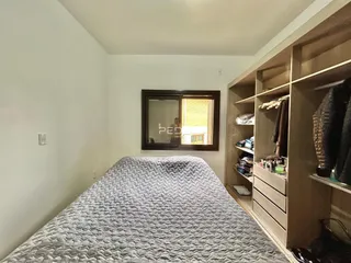 Quarto com cama grande e armário de madeira.