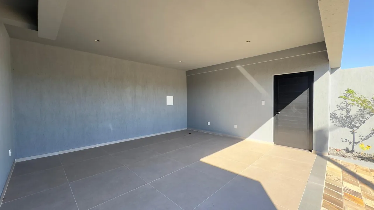 Esta é uma sala ampla e moderna com piso claro e paredes lisas.