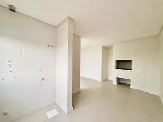 Hall de entrada com paredes brancas e piso claro.
