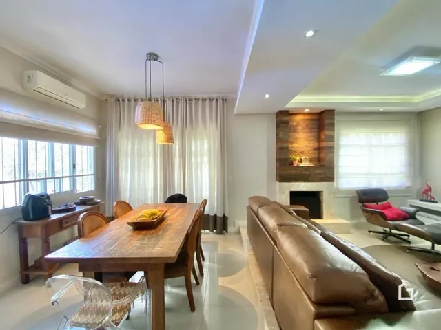 Uma sala de jantar com mesa de madeira e sofá marrom.
