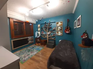 Quarto com móveis de madeira e parede azul.