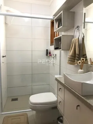 Foto de um banheiro com revestimento branco e azulejos.