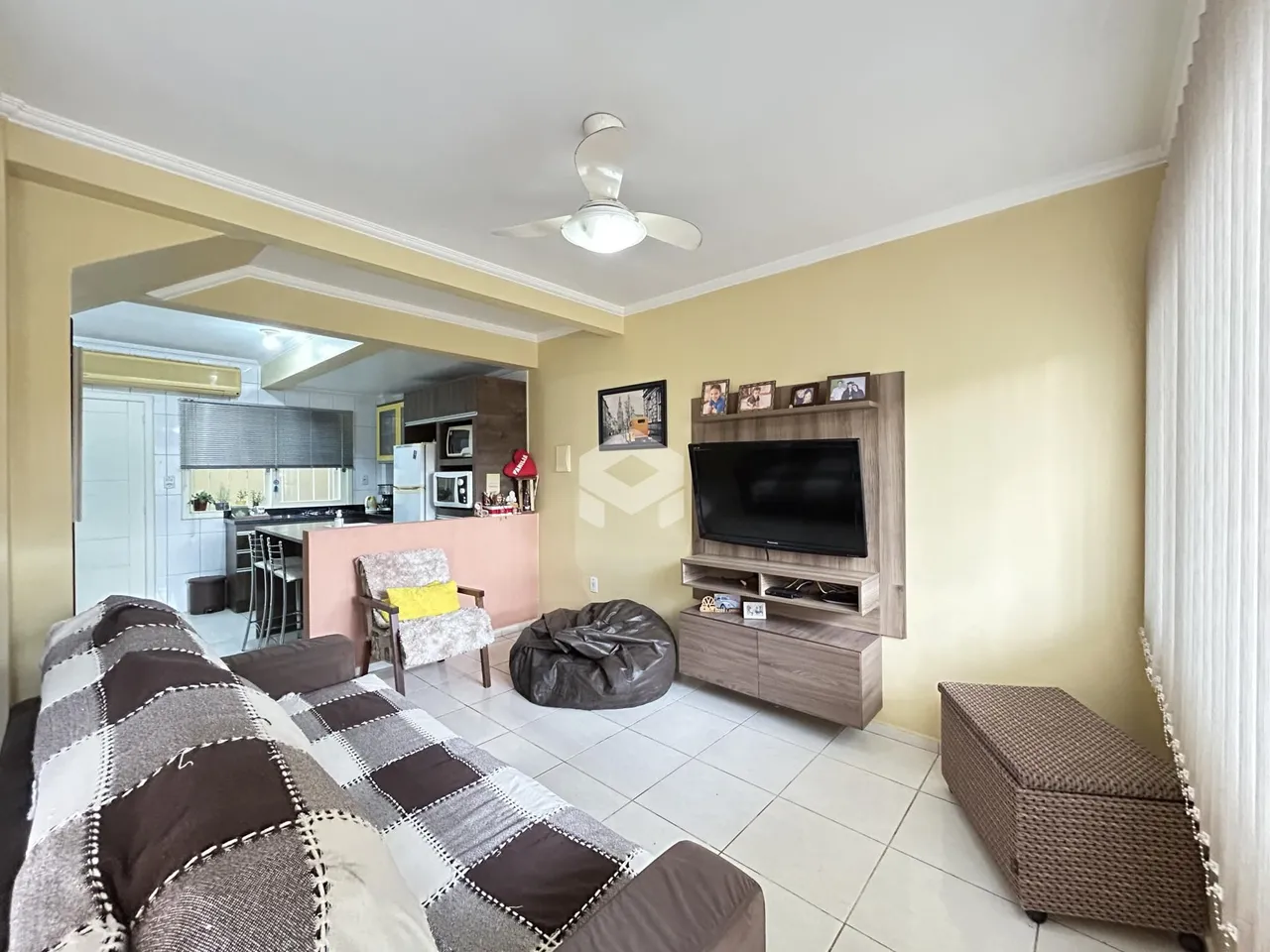 Sala de estar com sofá e vista para a cozinha em Lajeado, Brasil.