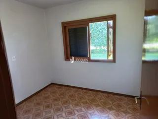 Uma sala interna com piso de cerâmica e janela.