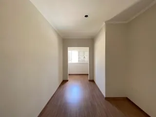 Corredor interno de uma residência com piso de madeira.