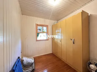 Uma foto de um cômodo interno com paredes brancas e armários amarelos.