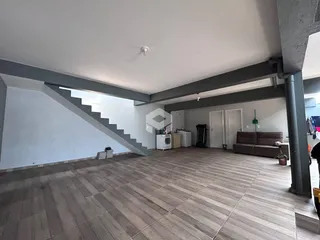 Vista interna de uma área com piso de cerâmica e escadaria.