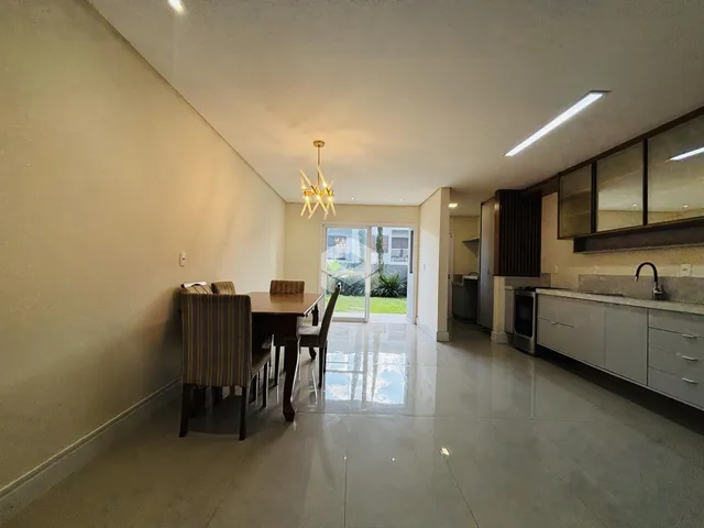 Sala de jantar e cozinha com piso de cerâmica e porta de vidro para o exterior.