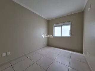 Uma sala interna com piso de cerâmica e janela.