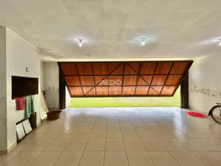 Corredor interno com piso de cerâmica e abertura para o jardim.