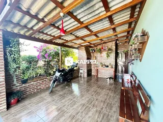 Ambiente interno com teto de madeira exposta e vista para um jardim.