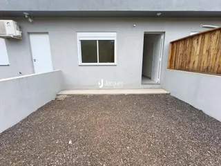 Parede externa de uma residência em Lajeado, Brasil, com piso de cascalho.