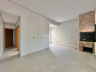 Ambiente interno amplo com paredes brancas e piso claro.