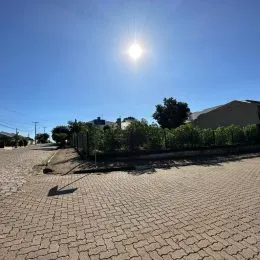 Vista externa de uma área pavimentada sob um céu azul claro.