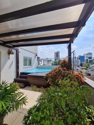 Vista da área externa com piscina e vegetação.