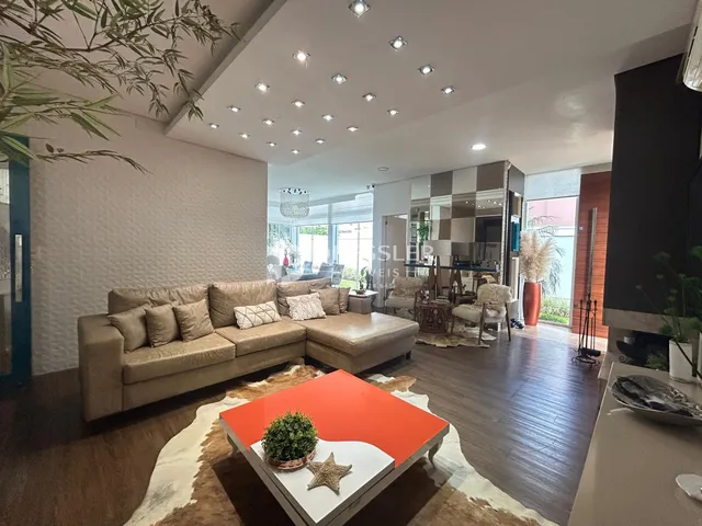 Sala de estar ampla com sofá e piso de madeira.
