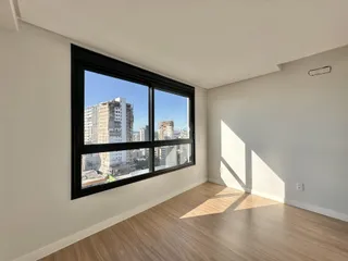 Sala de estar com grande janela de vista para a cidade.