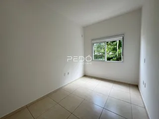 Vista interna de um cômodo com piso de cerâmica e janela.