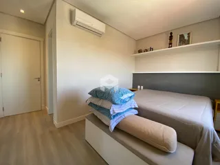 Quarto moderno com cama e painel de cabeceira.