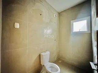 Foto de um banheiro interno com paredes revestidas de cerâmica.