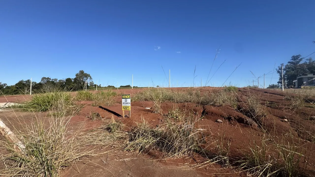 Vista de uma área de terra seca com vegetação rasteira e uma placa de venda em Lajeado.