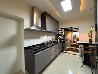 Cozinha moderna com armários escuros e bancada em um imóvel no Brasil.
