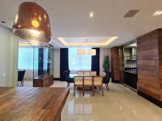 Interior de uma sala com mesa de madeira e painéis de vidro.
