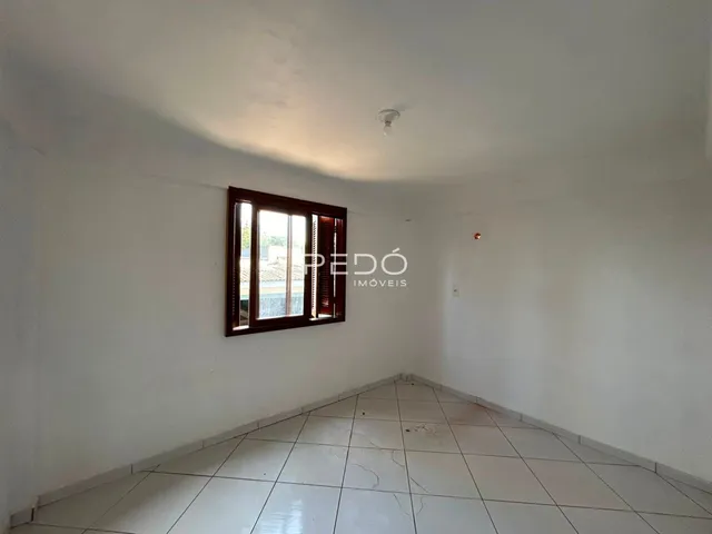 Vista interna de um ambiente com piso de cerâmica e janela.