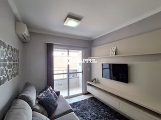Foto de uma sala de estar com sofá e televisão em um apartamento.