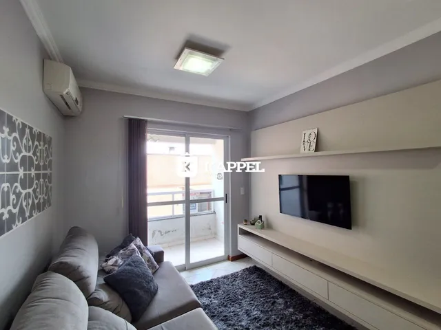 Foto de uma sala de estar com sofá e televisão em um apartamento.