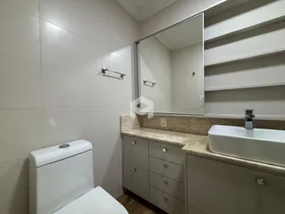 Banheiro moderno com bancada e vaso sanitário.