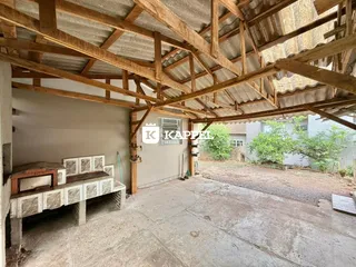 Foto do interior de uma estrutura em construção com vigas de madeira expostas.