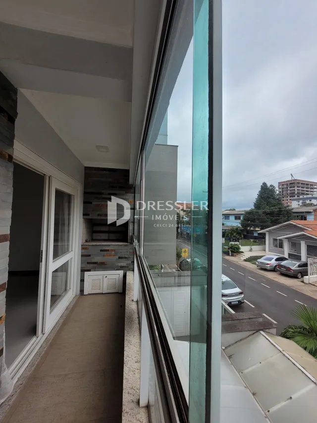 Vista interna de um corredor com porta de vidro em uma propriedade em Lajeado.