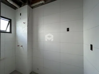 Parede interna com revestimento cerâmico e janela em um ambiente.