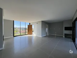 Sala de estar ampla com piso de cerâmica e grandes portas de vidro.