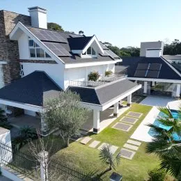 Vista externa da residência com telhado escuro e área de garagem.