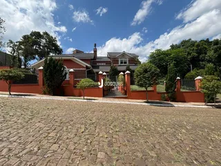 Fachada de uma residência em Lajeado, Brasil, com muro e paisagismo.