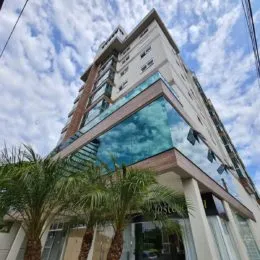 Fachada moderna de um edifício residencial em Lajeado, Brasil, com grandes painéis de vidro.