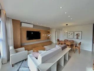 Sala de estar moderna com sofá e área de jantar em um apartamento.