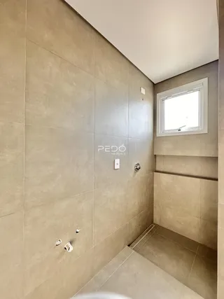 Foto de um banheiro com revestimento cerâmico claro.