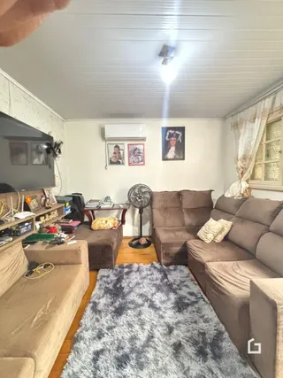Sala de estar com sofá e televisão em um imóvel no Brasil.