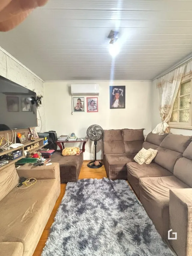 Sala de estar com sofá e televisão em um imóvel no Brasil.