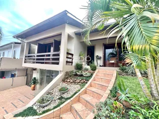 Fachada de uma casa em Lajeado, Brasil com jardim e escadaria externa.