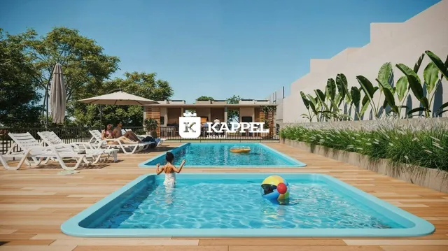 Foto de uma piscina externa com espreguiçadeiras e área verde em um condomínio.