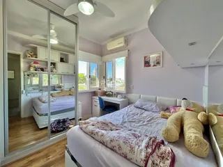 Quarto com cama e armário em ambiente claro.