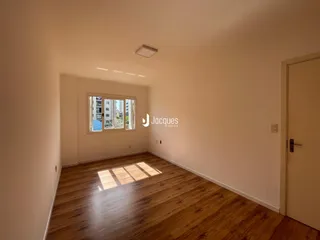 Sala de estar com piso de madeira e janela.