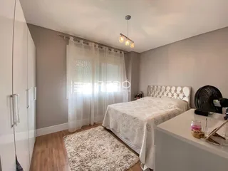 Quarto com cama, armário e piso de madeira clara.