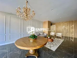Sala de estar com mesa de madeira e lustre.