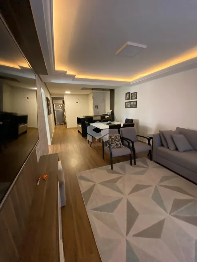 Foto de um corredor interno de uma residência com piso de madeira.